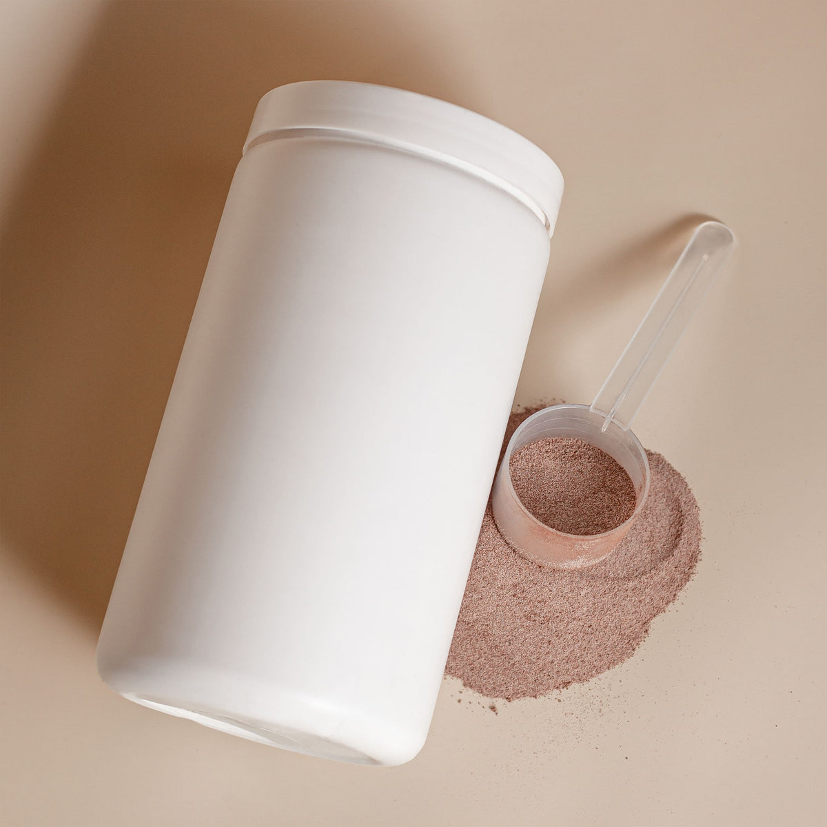 A tub of collagen powder with a scoop beside it