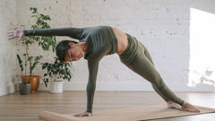 A woman doing a gentle yoga stretch on a mat during active recovery