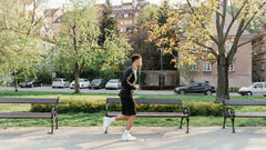 A man in activewear jogging on a sunny park path