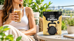 A person on a sunny patio with an iced protein coffee and the OrganiiLand Protein Coffee bag