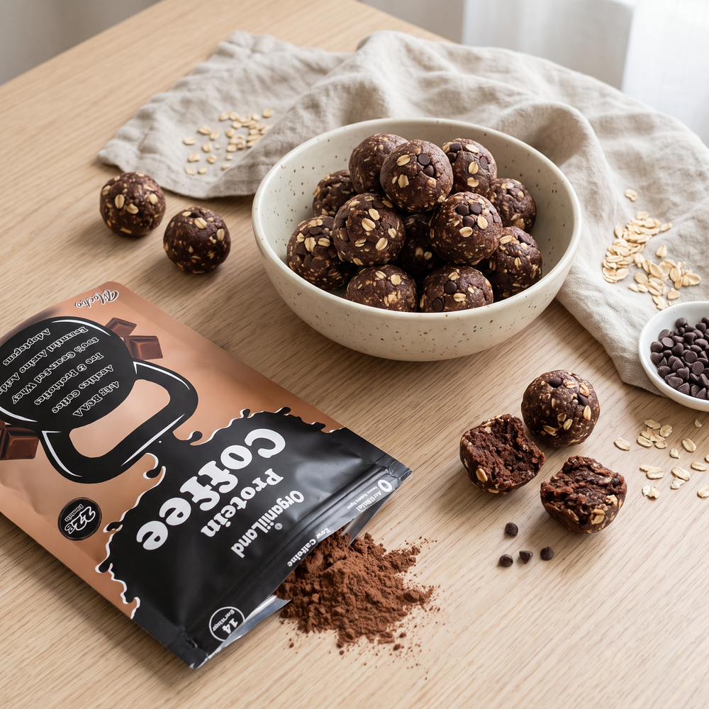 No-bake protein coffee energy bites in a ceramic bowl on pale oak beside an opened OrganiiLand Mocha Protein Coffee bag
