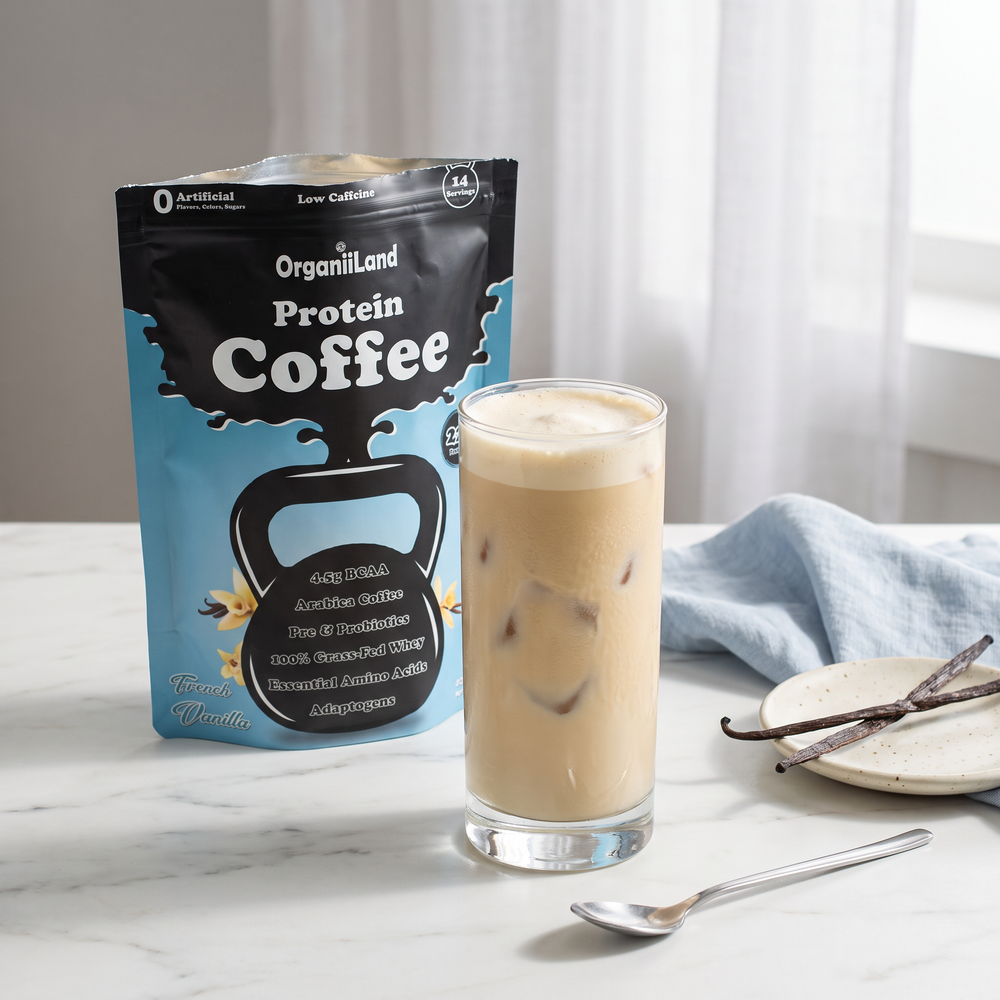 Iced vanilla protein latte in a tall glass on white marble with an opened OrganiiLand French Vanilla Protein Coffee bag
