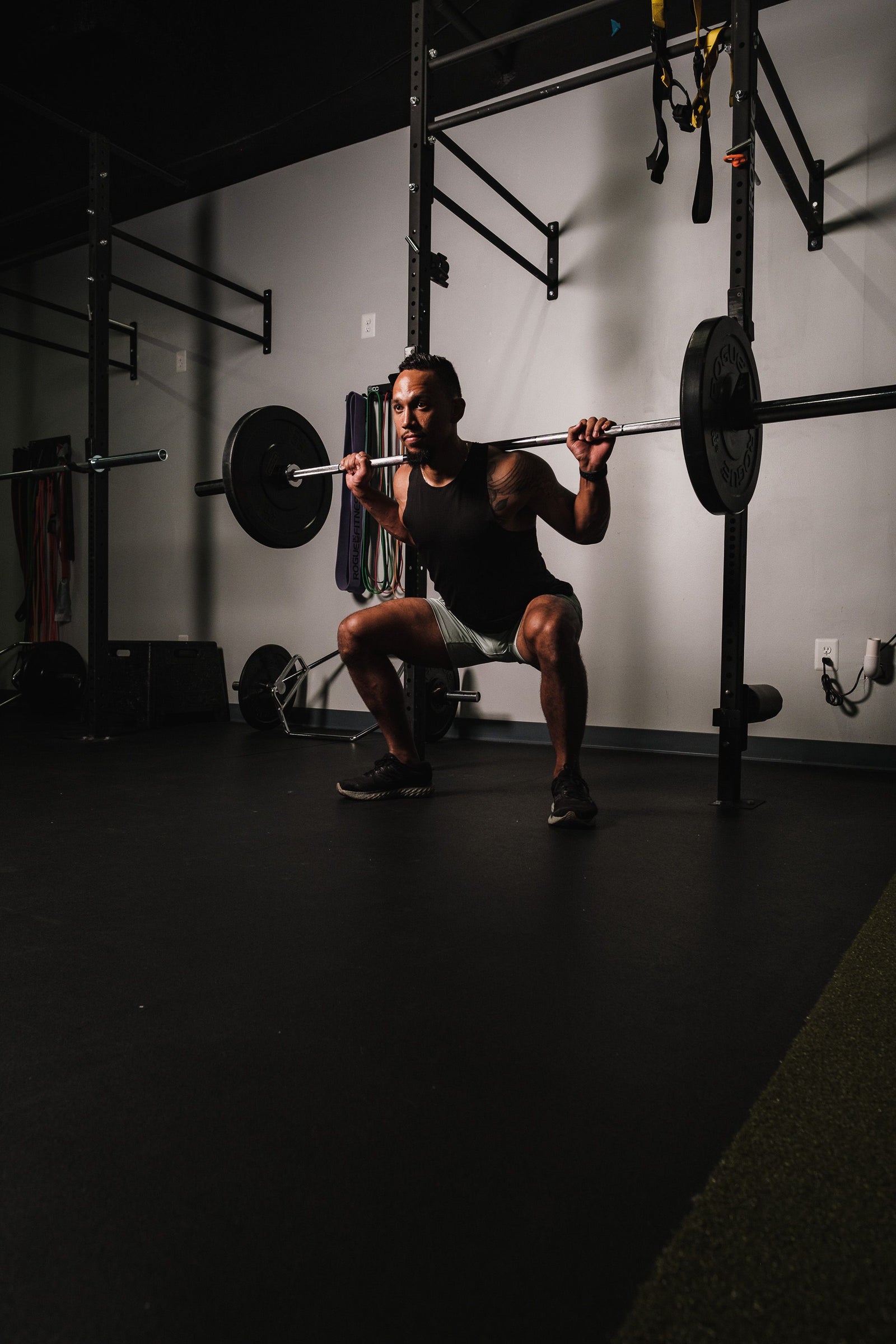 Man performing a barbell back squat, a foundational beginner compound lift