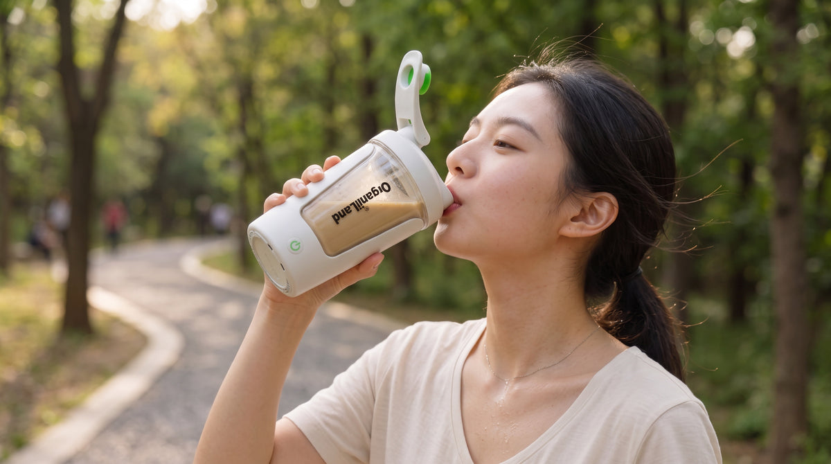 A woman drinking iced protein coffee from an OrganiiLand electric shaker in a bright kitchen